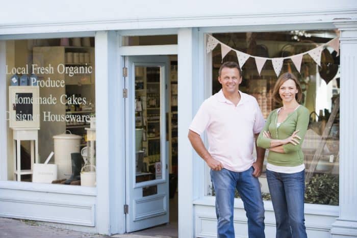 couple standing in front of small business